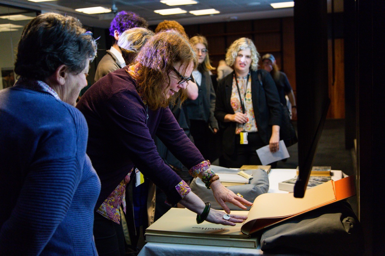 People looking at rare books on display on a table