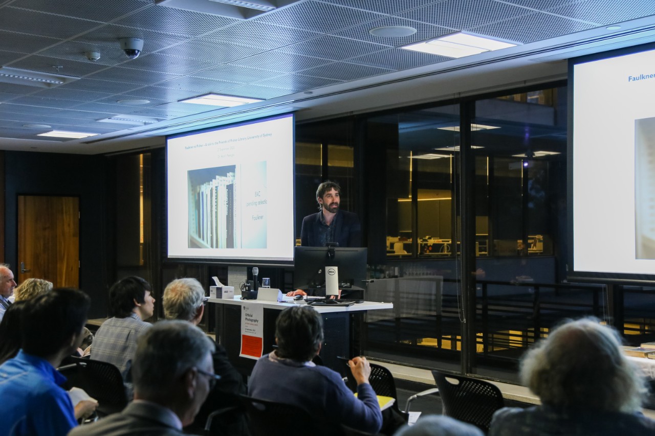 Dr Aaron Nyerges presenting in front of a room of people