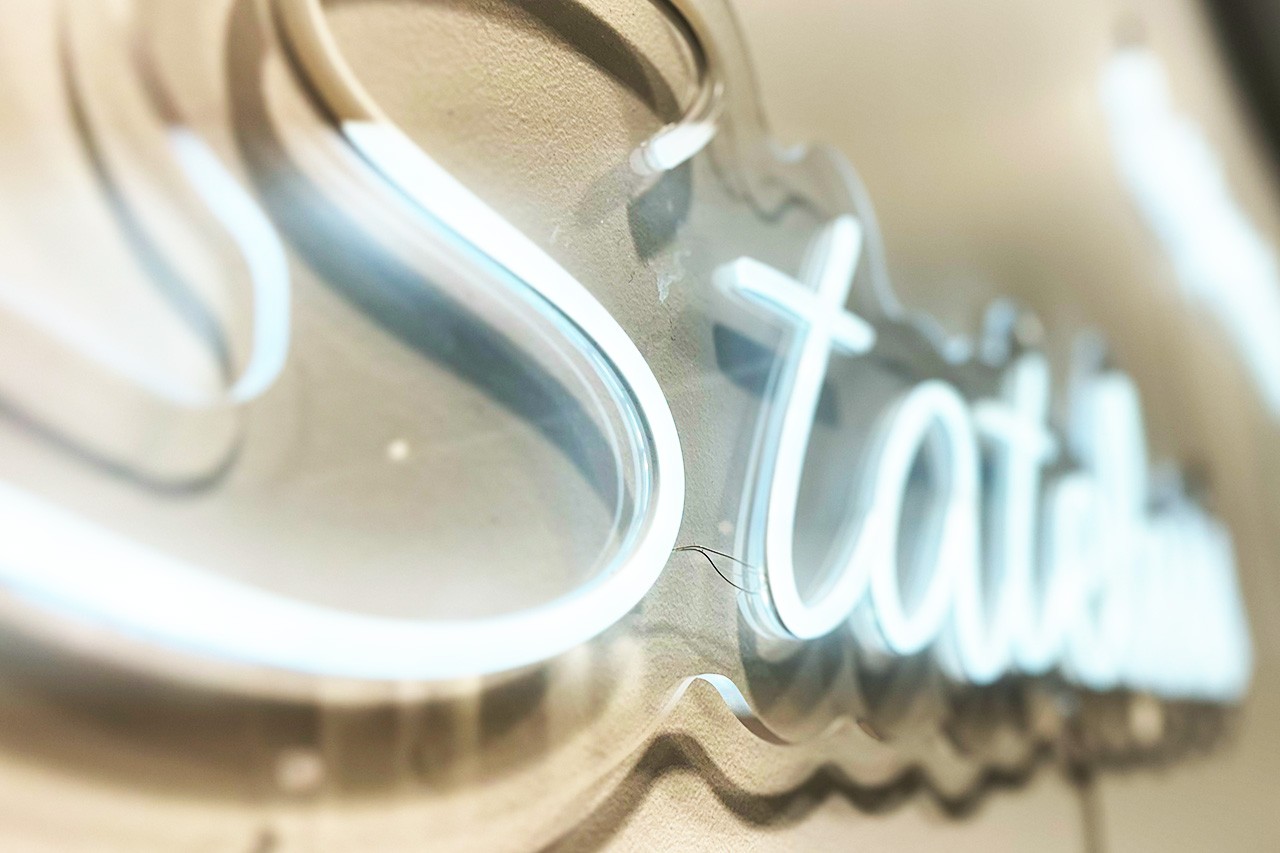 An extreme closeup of a white neon sign that focuses on the word Stateless