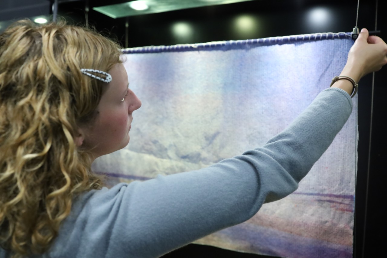 Artist hanging up their artwork 