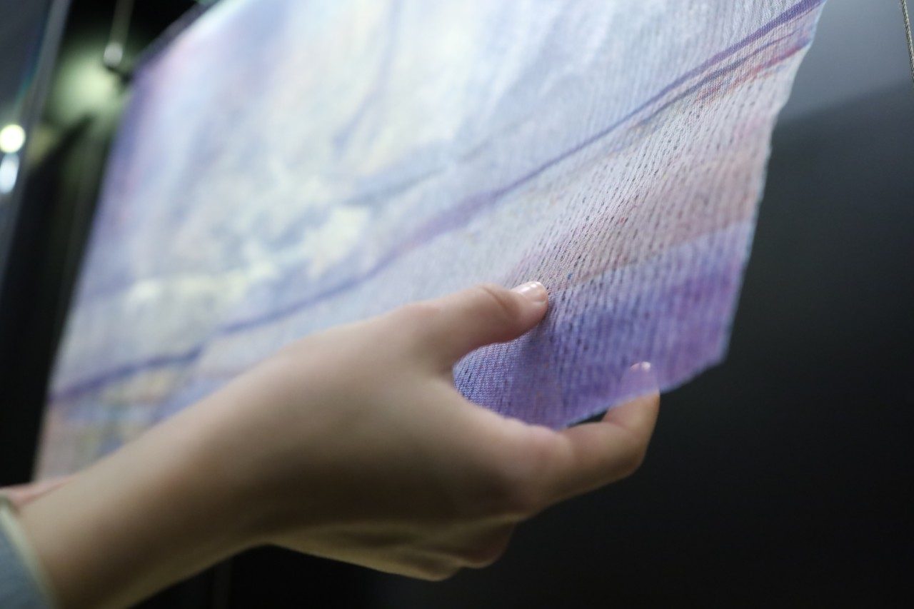 close up of fabric with hands touching the corners