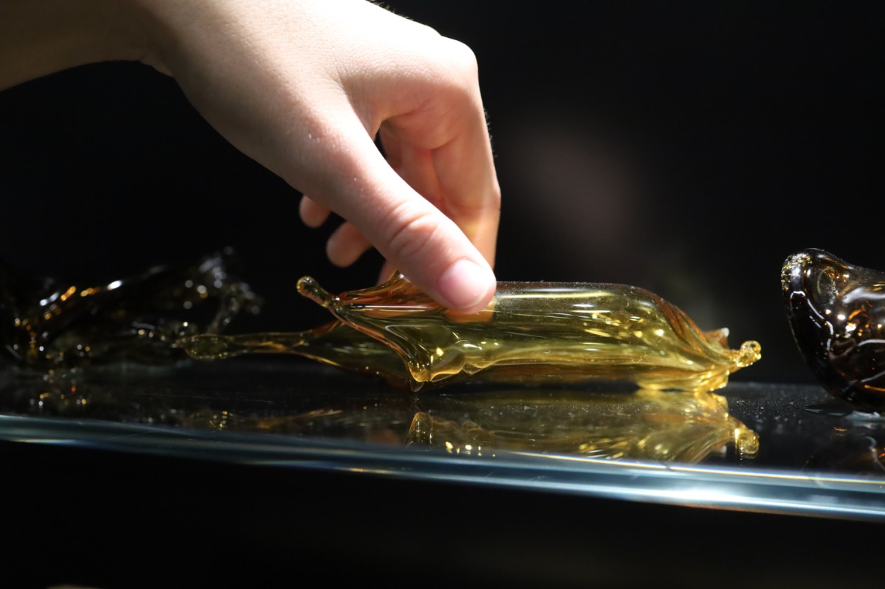 artist holding glass artwork
