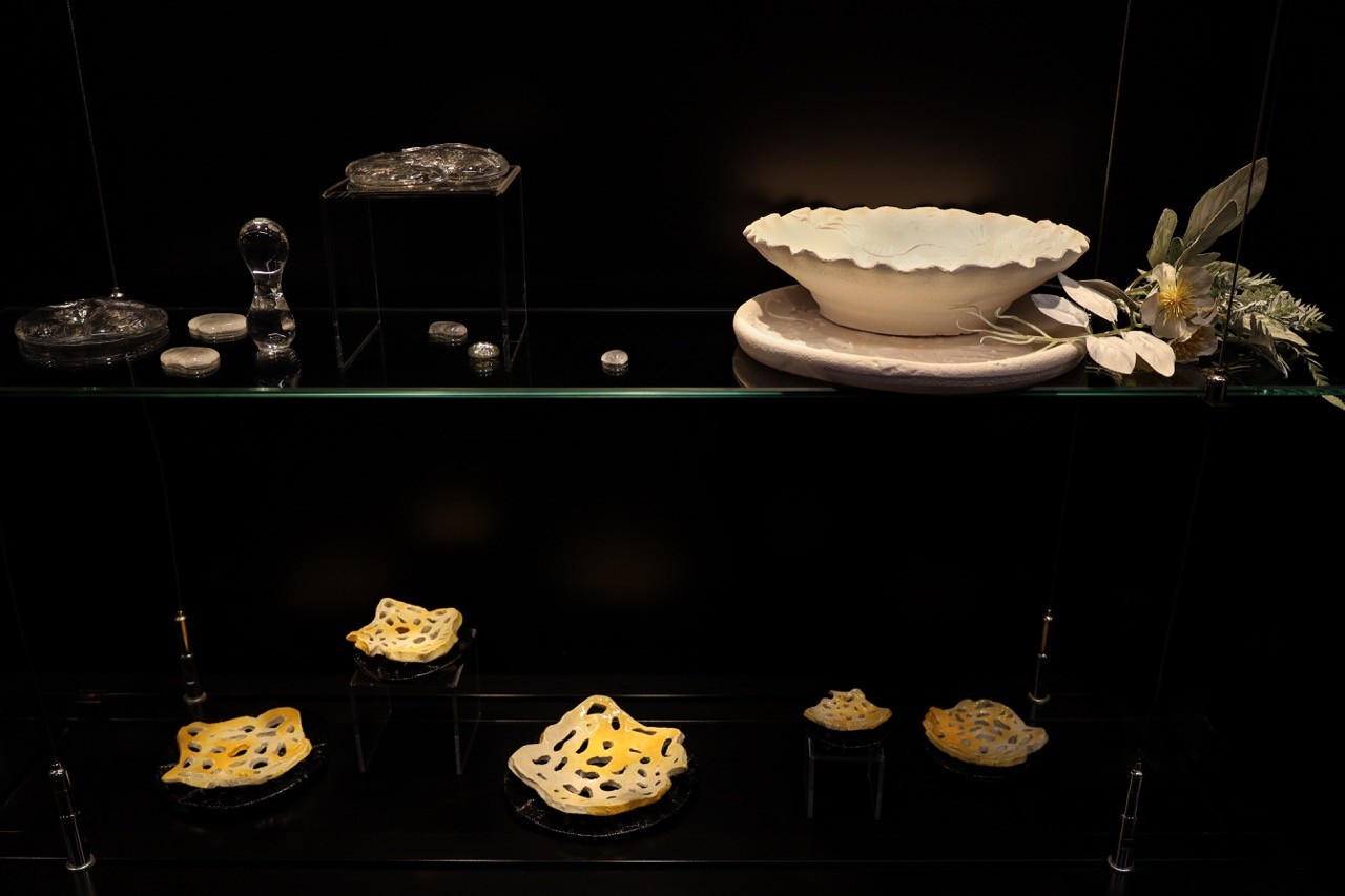 A variety of glass and ceramic sculptures displayed in a glass cabinet