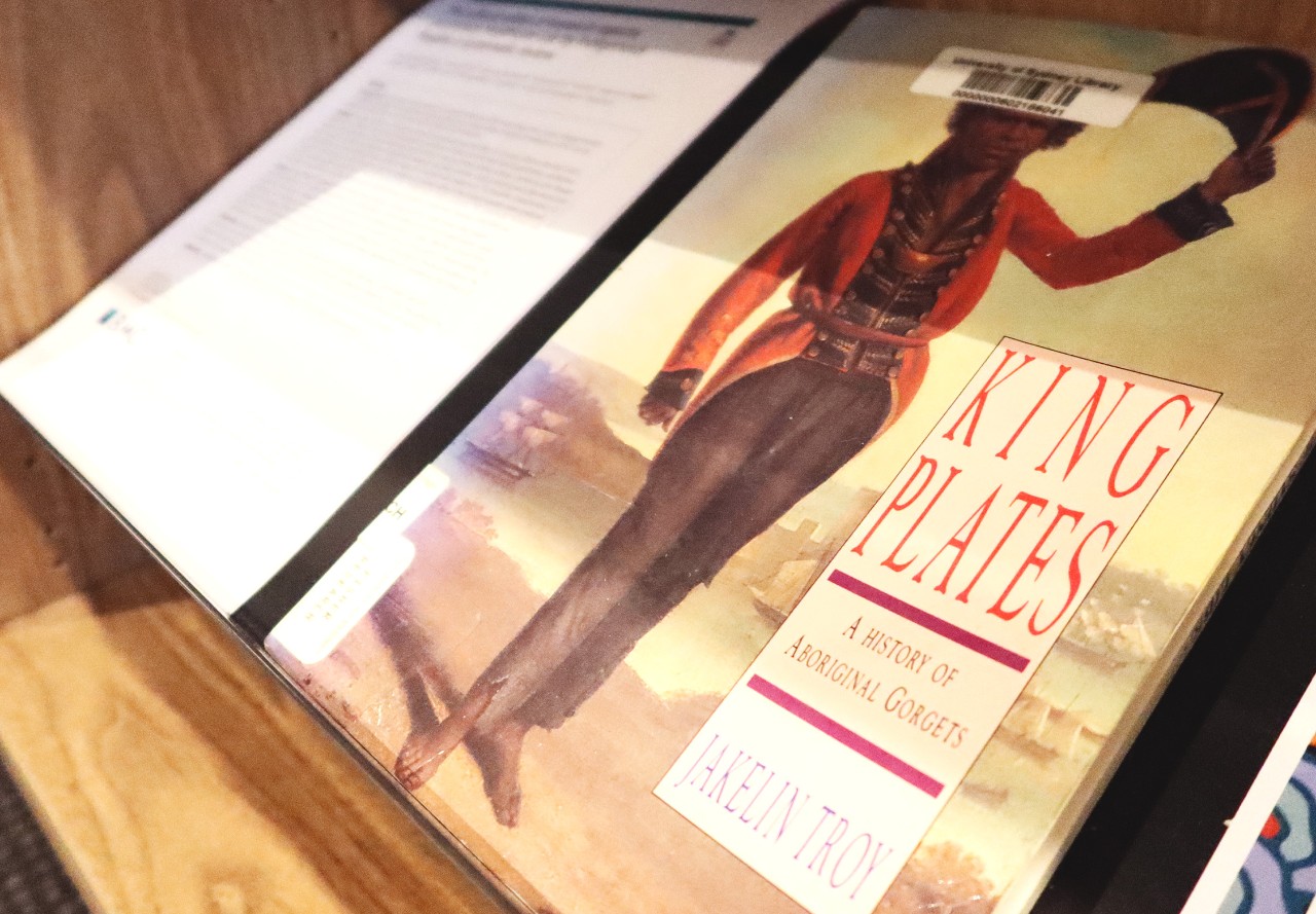 A side angle shot of a book cover, portraying an Indigenous figure wearing period clothes