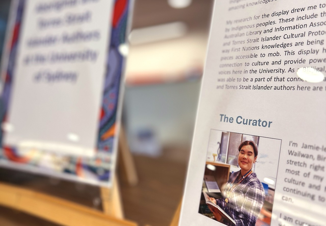 an angle shot of A3 stands with information on a book display, with the focus on the shot of the curator