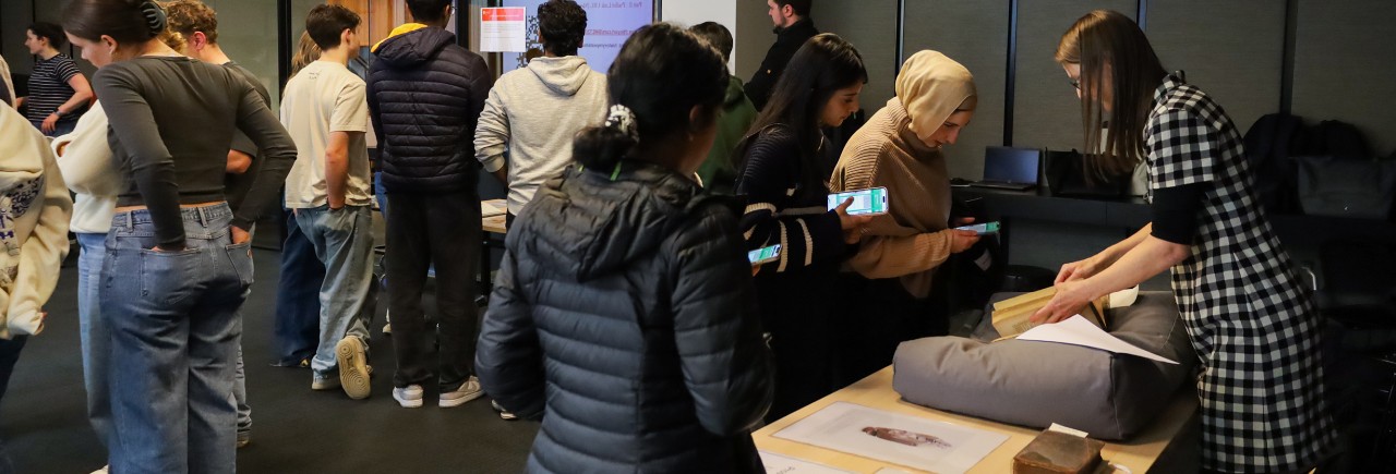 Groups of students huddled in groups during the Object Based Learning workshop