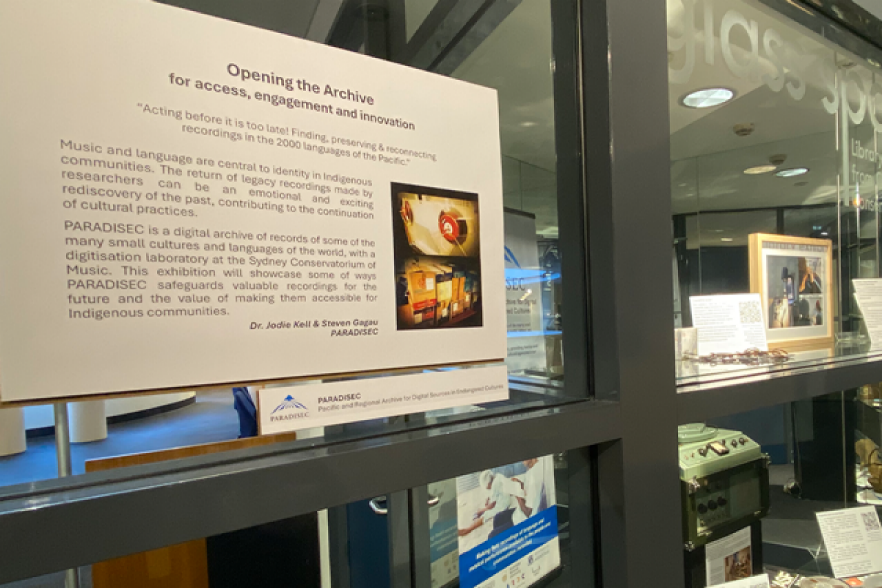 A signage on an angle for an exhibition on a glass panel