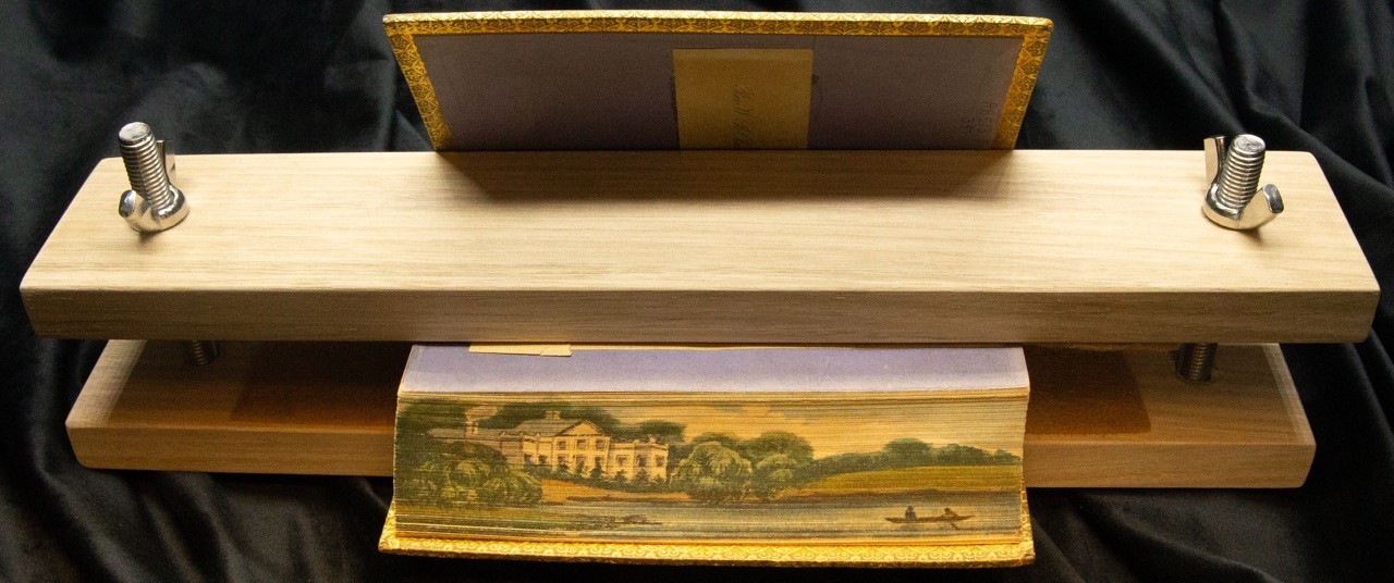 Fore-edge painting on a book, held in place with a clamp