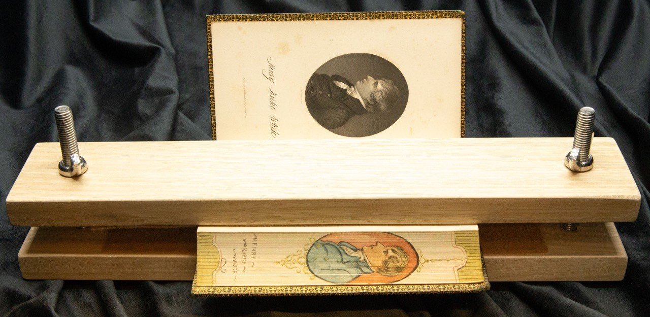 Fore-edge painting on a book, held in place with a clamp