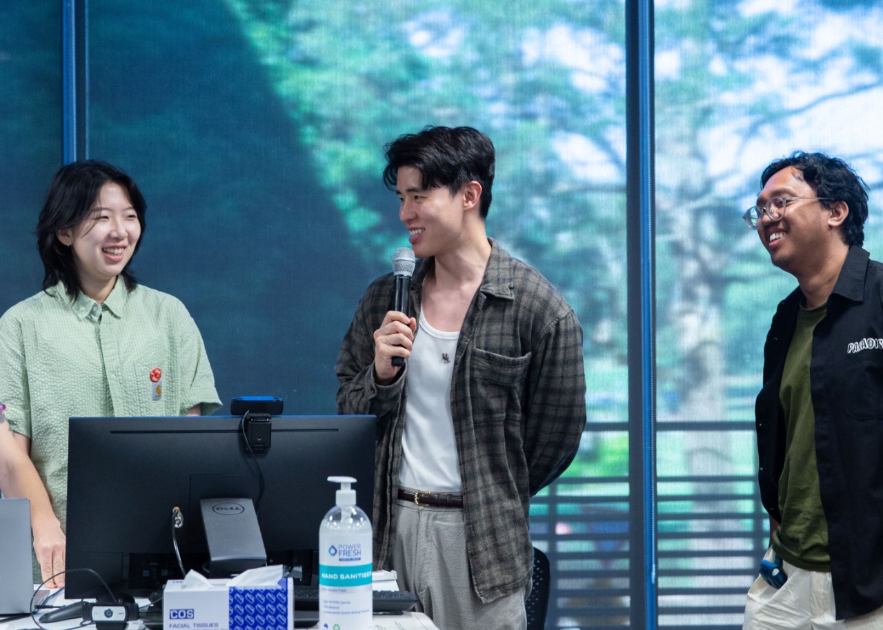 A colour photograph depicting three people smiling while presenting. Left to right, they are Peiyun Li, Hymn Sakol Sopitarchasak, and Abdullah Faqih